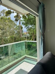 a window with a view of a balcony at Ayaan Quintet Evergreen with FIFA & Private Parking in Tanah Rata