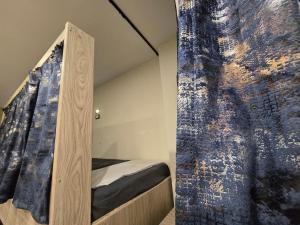 Un dormitorio con una cama y una pared. en Sheraton Hostel - Hurghada, en Hurghada