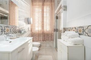 a white bathroom with a toilet and a sink at Cagliari Central Rooms With Port View in Cagliari
