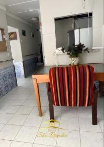a dining room with a table and a chair at Casa diária in Sao Paulo