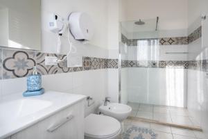 a white bathroom with a toilet and a sink at Cagliari Central Rooms With Port View in Cagliari