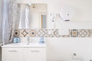 a bathroom with a sink and a mirror at Cagliari Central Rooms With Port View in Cagliari