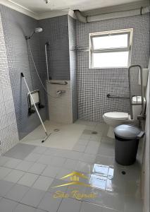 a bathroom with a toilet and a shower and a window at Casa diária in Sao Paulo