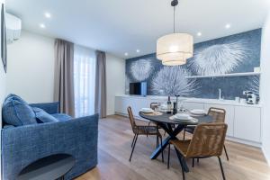 a dining room and kitchen with a table and a couch at Pico Apartments - Roma 20 in Sanremo