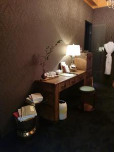 a desk with a lamp and a chair in a room at 杭州西湖茶荟酒店 G hotel west lake hotel in Hangzhou
