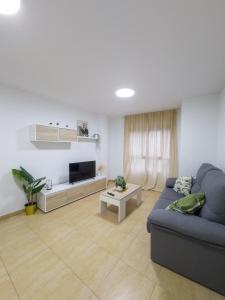 a living room with a blue couch and a tv at Apartamento San Diego 1 - Almyra Inmobiliaria in Los Alcázares