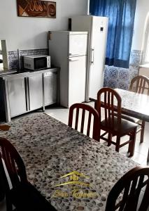 a kitchen with a table with chairs and a refrigerator at Casa diária in Sao Paulo +3 photos