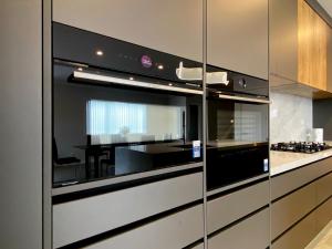a kitchen with a black and white oven at Brand-New Large house Castlebane Drive in Auckland