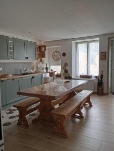 a kitchen with a large wooden table and benches at Le petit charme in Melay
