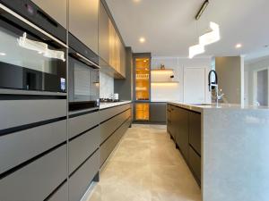 a kitchen with white and black cabinets and a counter at Brand-New Large house Castlebane Drive in Auckland