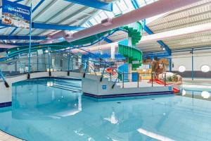an indoor swimming pool with a water slide at Newton Beach retreat in Porthcawl