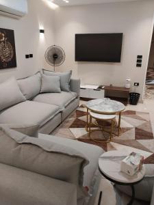 a living room with a couch and a flat screen tv at Heliopolis Ultra Luxury Panoramic Apt Near Cairo Airport in Cairo