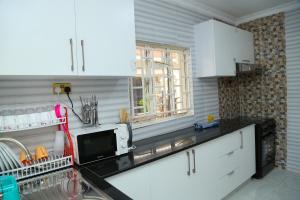 a kitchen with white cabinets and a sink at SixPoint Victoria in Kisumu