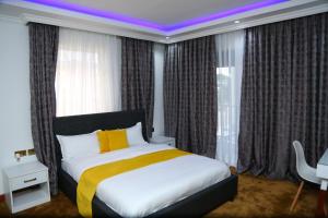 a bedroom with a king sized bed with a purple lighting at SixPoint Victoria in Kisumu +12 photos