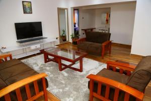 a living room with a couch and a tv at SixPoint Victoria in Kisumu