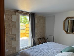 a bedroom with a bed and a large window at Les chais du Fourneau - Séjours au cœur des vignes du Médoc in Saint-Christoly-Médoc +32 photos