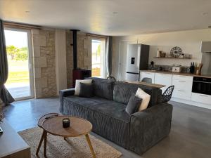 a living room with a couch and a table at Les chais du Fourneau - Séjours au cœur des vignes du Médoc in Saint-Christoly-Médoc