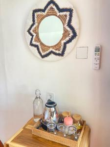 a mirror on a wall above a table with a tray of dishes at Four Elements Eco Dive Resort in Gili Islands