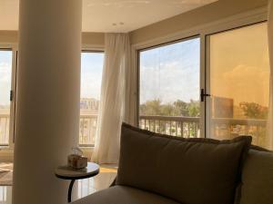a living room with a couch and a large window at Heliopolis Ultra Luxury Panoramic Apt Near Cairo Airport in Cairo