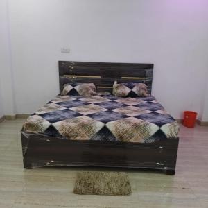a bed in a room with a checkered bedspread at SHREE MANDAP HOTEl 