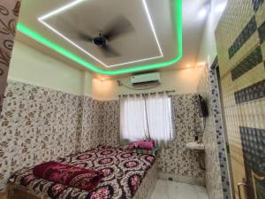 een kamer met een bed met een plafond met groene lichten bij Mayapur Yatri Nivas in mayapur +25 foto's