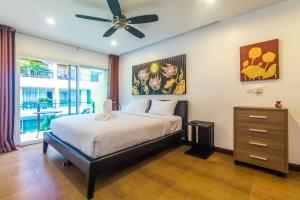 a bedroom with a bed and a ceiling fan at AP Grand Residence by Lofty in Kamala Beach +39 photos