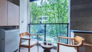 a kitchen with two chairs and a large window at MuYun Villa Lijiang in Lijiang