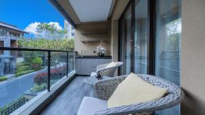 a balcony with a wicker chair and a table at MuYun Villa Lijiang in Lijiang