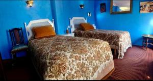 a hotel room with two beds and blue walls at Hotel Dar Dalia Tetouan in Tetouan +5 photos