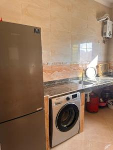 a kitchen with a washing machine and a counter at Appartement azla plage in Oulad Akkou +7 photos
