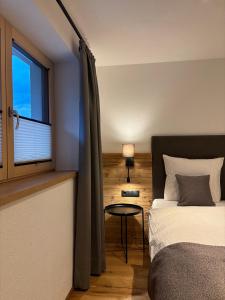 a bedroom with a bed and a window and a table at Apart s'Bergnestli - 300 m bis zur Skipiste & Silvretta Card Premium Partnerbetrieb in See