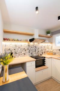 cocina con armarios blancos y microondas negro en Sta Perivolia, en Tinos