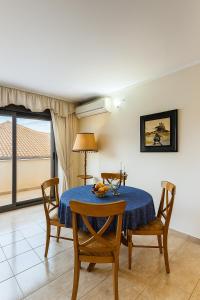 a dining room with a blue table and chairs at Aba Jacuzzi in Tirana
