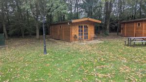 a wooden building in a yard with a picnic table at Snowdrop Cabin Retreat dog friendly peaceful in Huttoft
