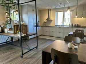 a kitchen and dining room with tables and chairs at Västerhöjdsgården in Skövde