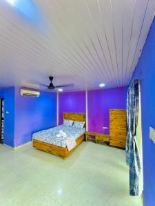 une chambre avec un lit et un mur violet dans l'établissement Eagle villa, à Kārli