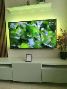 a flat screen tv sitting on a wall at SK apartament in Plungė +3 photos