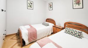 a bedroom with two beds and a wooden floor at AG Piso Isabema a 400m del centro de Carballo in Carballo +5 photos