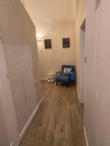 a hallway with a blue chair in a room at Kindermann Residence in Łódź
