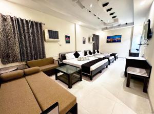 a living room with several beds and a couch at Sarovar Regency in Amritsar