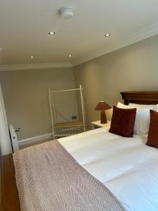 a bedroom with a large white bed and a mirror at Derry City Apartment in Derry Londonderry