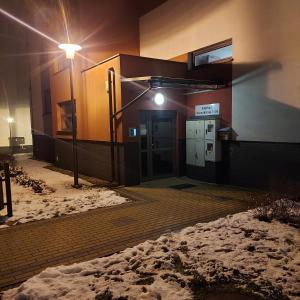a building with a door and a light in the snow at Apartament ZARA Self Check In in Rzeszów