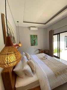 a bedroom with a bed with a lamp and a window at Ulusunny Bingin in Bingin Beach +41 photos