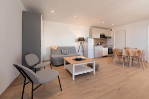 a living room with a couch and a table and chairs at Tribord Bâbord Draps Parking Wifi in Arzon