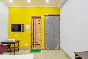 a room with a yellow wall and a door at Hotel O Annapurna Plaza in Thākurdwari +26 photos