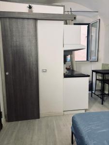 a kitchen with a white refrigerator and a table at Gilli Suite Sanremo in Sanremo
