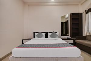 Un dormitorio con una gran cama blanca y un sofá. en Townhouse Prime Stay, en Indore 28 fotos más