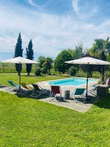 a group of chairs and umbrellas next to a pool at Le Truc Bidule in Murs