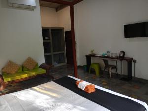 Cette chambre comprend un lit, un canapé et une table. dans l'établissement Passport Villa, à Siem Reap
