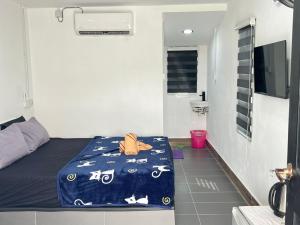 a room with a bed with a blue comforter on it at Amani village in Kangar